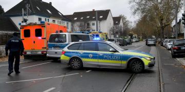 Polizeiwagen stehen auf der Hauptstrasse vor einer Tankstelle.