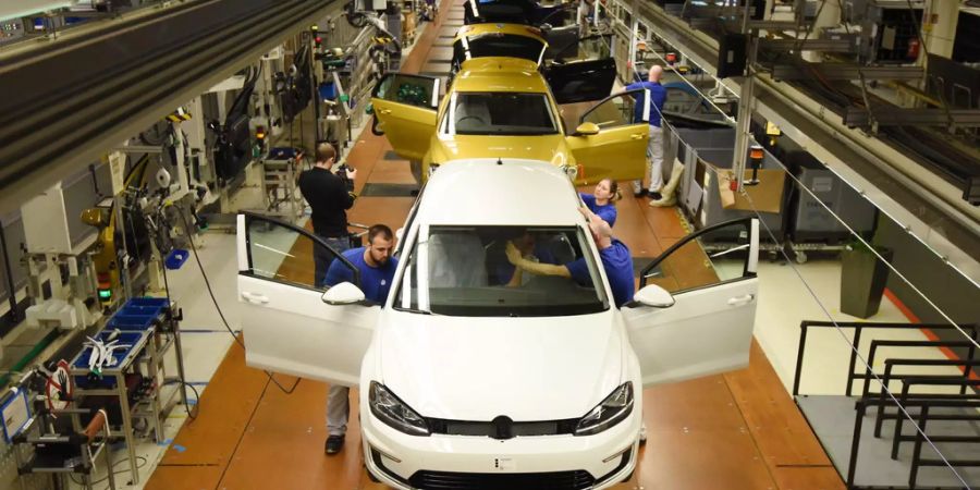 Mitarbeiter montieren am 09.03.2017 auf einer Fertigungsstrecke im Volkswagen Werk in Wolfsburg (Niedersachsen) den VW Golf 7.