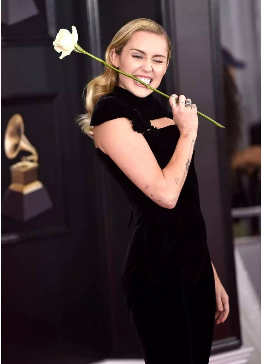 Schwarzes Outfit und weisse Rose: Miley Cyrus kombiniert gleich beides.