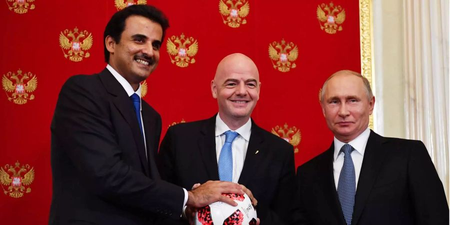 Fifa-Präsident Infantino (Mitte) und Wladimir Putin mit einer symbolischen Übergabe der WM-Geschicke an den Emir von Katar (links).