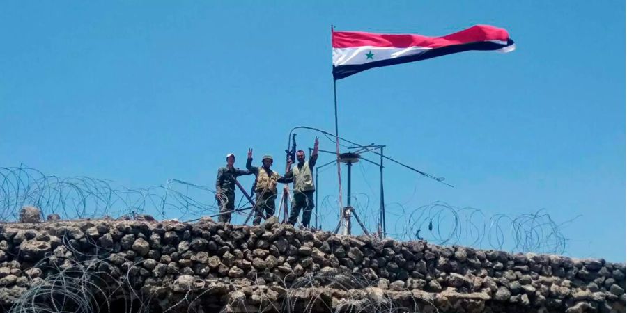 Syrische Regierungstruppen  jubeln mit einer gehissten Flagge (Themenbild).