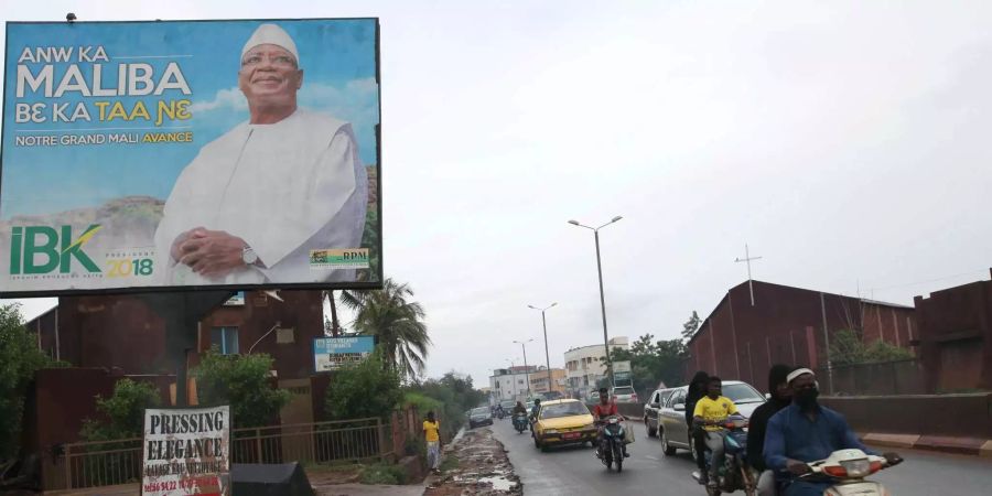 Motorrad-Taxis fahren an einem Wahlplakat des Präsidenten von Mali, Ibrahim Boubacar Keita, vorbei. Die Bürger im westafrikanischen Krisenstaat Mali wählen am Sonntag einen neuen Präsidenten. Die grössten Chancen werden dem amtierenden Staatschef Ibrahim Boubacar Keïta (71) zugerechnet, der sich um eine zweite Amtszeit bewirbt.