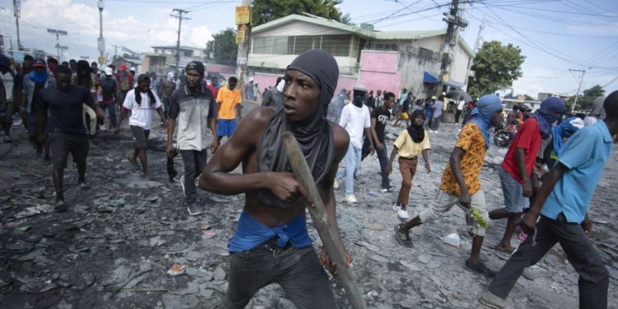 dpatopbilder - Ein Demonstrant trägt ein Holzstück, das eine Waffe simuliert, während einer Demonstration, die den Rücktritt von Premierminister Ariel Henry fordert, im Stadtteil Petion-Ville in Port-au-Prince, Haiti. Foto: Odelyn Joseph/AP/dpa