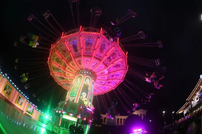 Ein bunt leuchtendes Kettenkarussell dreht sich am Oktoberfest vor der Bavaria auf der Theresienwiese. Oktoberfest