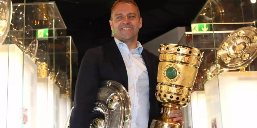 Coach Hansi Flick übergibt die Meisterschale und den Pokal an das Museum des FC Bayern München. Foto: Alexander Hassenstein/Getty Images Europe/FCB/dpa