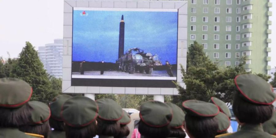 ARCHIV - Menschen stehen am im August 2017 auf dem Platz vor dem Hauptbahnhof in Pjöngjang, um die Übertragung eines Raketentests zu beobachten. Foto: Kim Kwang Hyon/AP/dpa