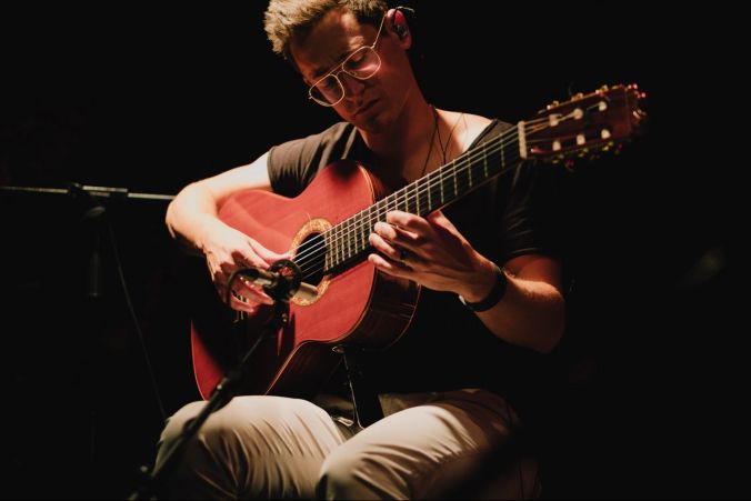 Durch virtuoses Gitarrenspiel.