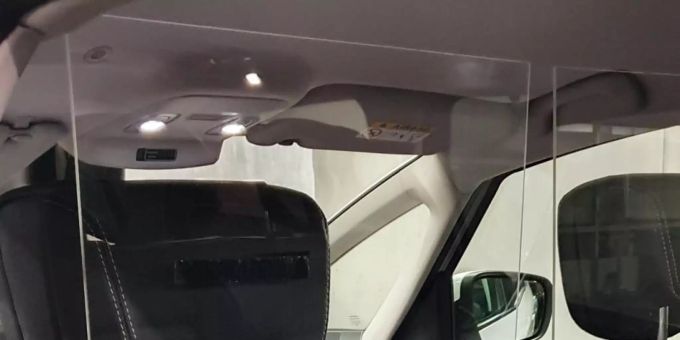 Plexiglasscheibe als Schutz im Taxi zwischen Fahrersitz und Rückbank.
