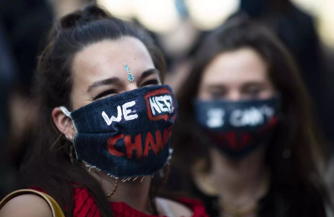 Eine Protestierende trägt einen Atemschutz mit der Aufschrift «Wir brauchen Veränderung». adama traoré affair