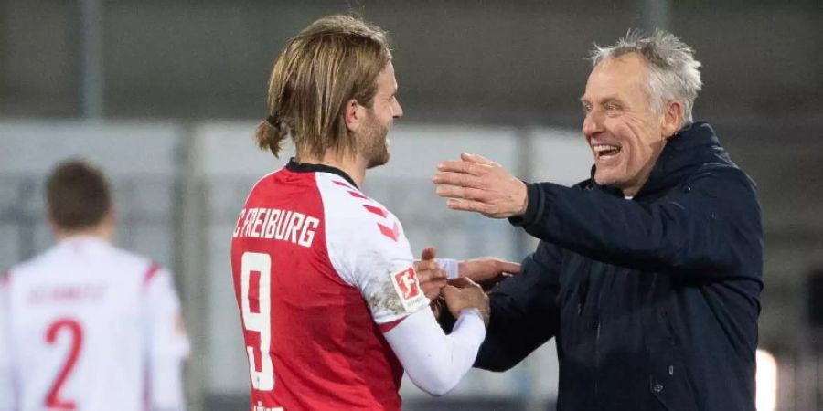 Freiburgs Trainer Christian Streich (r) freut sich nach dem Spiel mit Torschütze Lucas Höler. Foto: Sebastian Gollnow/dpa