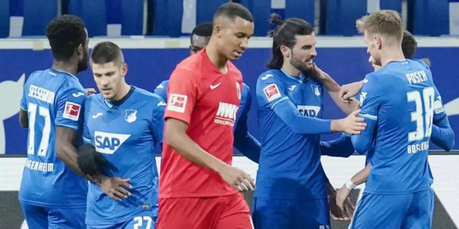 Die Spieler der TSG 1899 Hoffenheim (im Hintergrund) feiern das Tor zum 1:0. Foto: Uwe Anspach/dpa