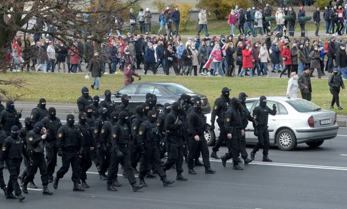 Belarussische Polizisten gehen am 1. November 2020 an einer Protestkolonne in Minsk entlang. Anti-Regierung Polizei Minsk