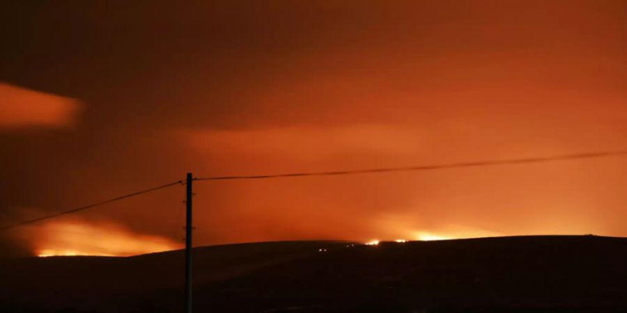 ARCHIV - Feuer ist am Horizont zu sehen, das im Dartmoor in der englischen Grafschaft Devon ausgebrochen ist. Die Moor- und Heidelandschaft ist für ihre bronzezeitlichen Gräber und Siedlungsspuren wie beispielsweise Steinkreise bekannt. Foto: Benjamin Lawley/Twitter/PA Media/dpa - ACHTUNG: Nur zur redaktionellen Verwendung im Zusammenhang mit der aktuellen Berichterstattung und nur mit vollständiger Nennung des vorstehenden Credits