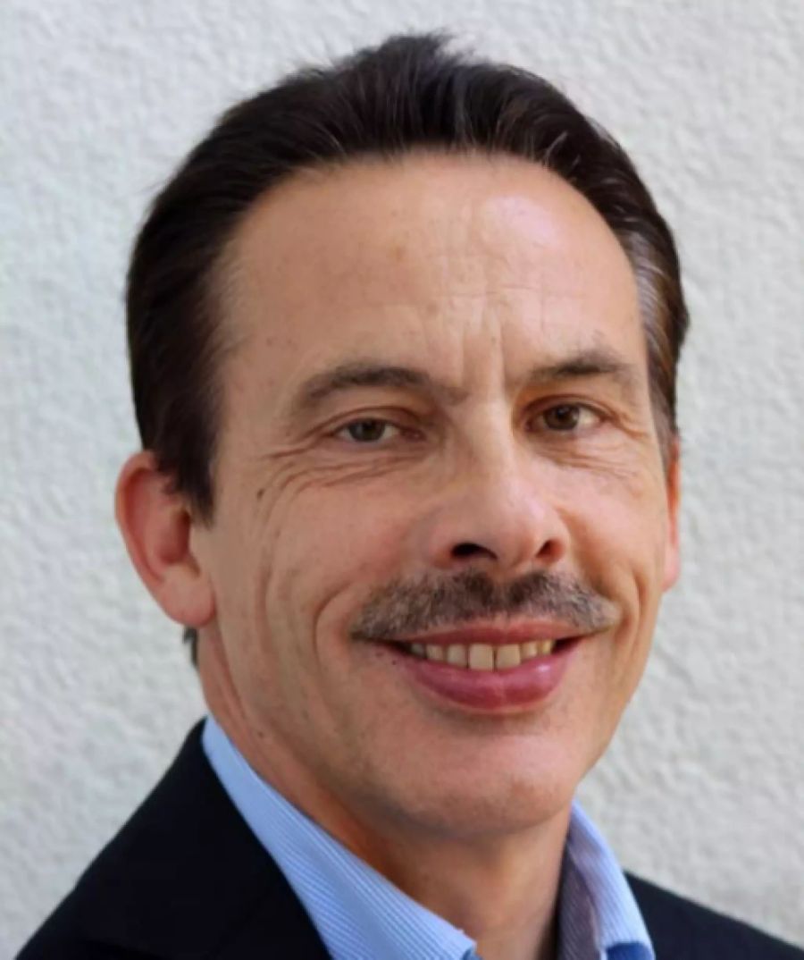 Nick Zepf, Generalsekretär, lacht mit echtem Schnauzer in die Kamera.