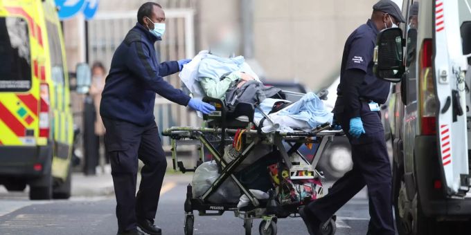 Ein Patient wird von zwei Männern auf einer Krankenbare von einem Krankenwagen zum «Royal London Hospital» gerollt. Coronavirus - Grossbritannien