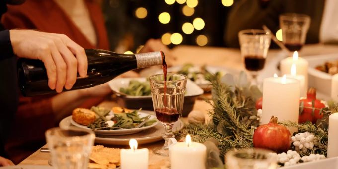 Damit auch der Magen zu Weihnachten zufrieden ist, sollte man den Verdauungsschnapps lieber weglassen. Weinflasche einschenken Weihnachtsessen