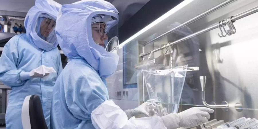 Laborantinnen der Firma Biontech simulieren die finalen Arbeitsschritte zur Herstellung des Corona-Impfstoffes an einem Bioreaktor. Foto: Boris Roessler/dpa