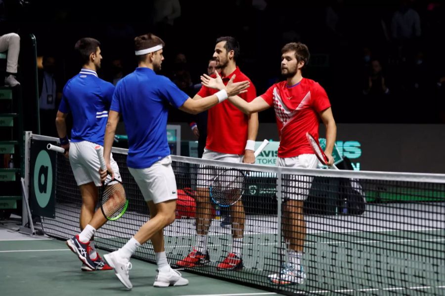 Novak Djokovic (L) und Filip Krajinovic bedanken sich bei Nikola Mektic (R) and Mate Pavic nach dem Doppel.