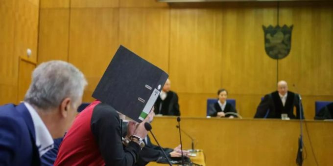 Mit einem Aktenordner vor dem Gesicht nimmt der Iraker Taha Al-J. vor der Urteilsverkündung im Frankfurter Oberlandesgericht auf der Anklagebank Platz. Foto: Frank Rumpenhorst/dpa-Pool/dpa Mit einem Aktenordner vor dem Gesicht nimmt der Iraker Taha Al-J. vor der Urteilsverkündung im Frankfurter Oberlandesgericht auf der Anklagebank Platz. Foto: Frank Rumpenhorst/dpa-Pool/dpa