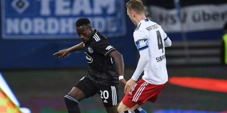 Der Düsseldorfer Spieler Khaled Narey (l) wurde von einer kleinen Gruppe von Zuschauern aus dem HSV-Block rassistisch beschimpft. Foto: Daniel Reinhardt/dpa