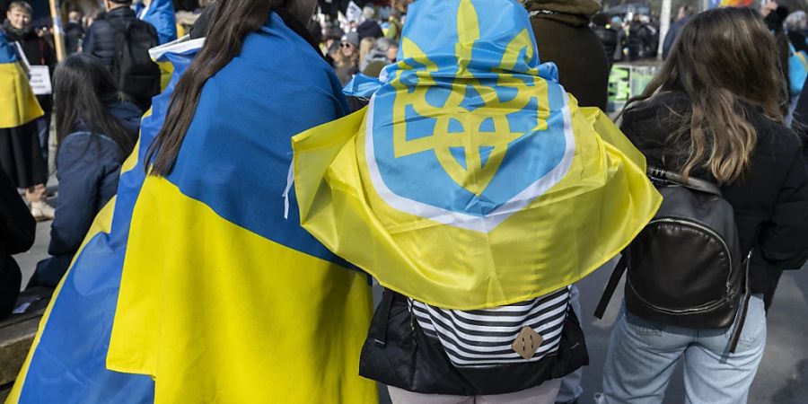 Personen tragen ukrainische Flaggen an der nationalen Friedenskundgebung in Bern. (KEYSTONE/Peter Schneider)