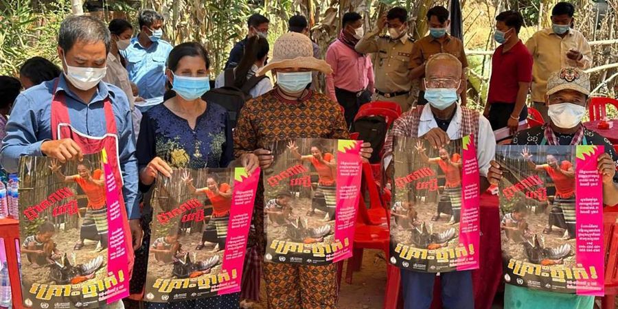 Dorfbewohner in der östlichen Provinz Prey Veng mit Plakaten, die auf die Bedrohung durch das Vogelgrippen-Virus aufmerksam machen.