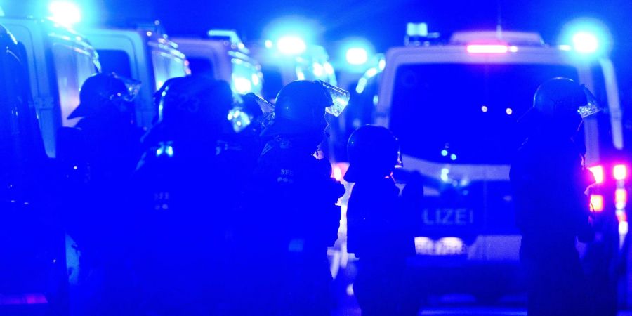 Polizisten stehen am Abend des 78. Jahrestages der Zerstörung Dresdens im Zweiten Weltkrieg zwischen Gegendemonstranten und einem Zug von Montagsdemonstranten in der Innenstadt.