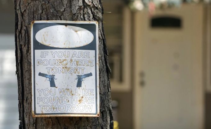 Ein Warnschild ist am Sonntag, dem 30. April 2023, vor dem Haus in Cleveland, Texas, zu sehen, in dem es am Freitagabend zu einer Massenerschießung kam. Schild an Baum
