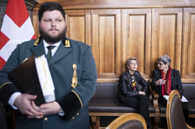 Bundesratsweibel Joël Seeberger, links, bewacht seine Chefin, Bundesrätin Karin Keller-Sutter, Mitte, die sich mit FinDel-Präsidentin Ursula Schneider Schüttel unterhält, nach der Debatte im Ständerat vom 12. April 2023. Karin Keller-Sutter