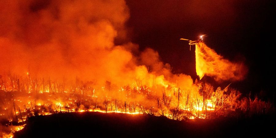 Ein Hubschrauber wirft Wasser auf das Thompson-Feuer