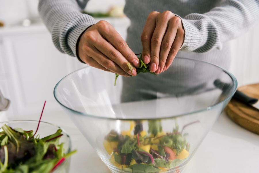 Eine Person bereitet Salat zu