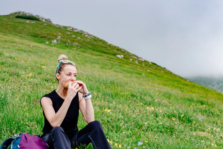 Frau isst Brot auf einem Berg