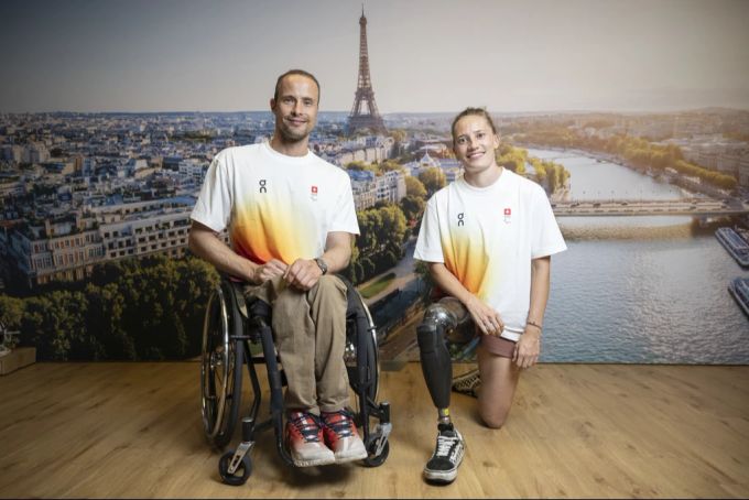 Paralympics 2024: Marcel Hug (l) und Elena Kratter (r) tragen an der Eröffnungsfeier die Schweizer Fahne. Paralympics