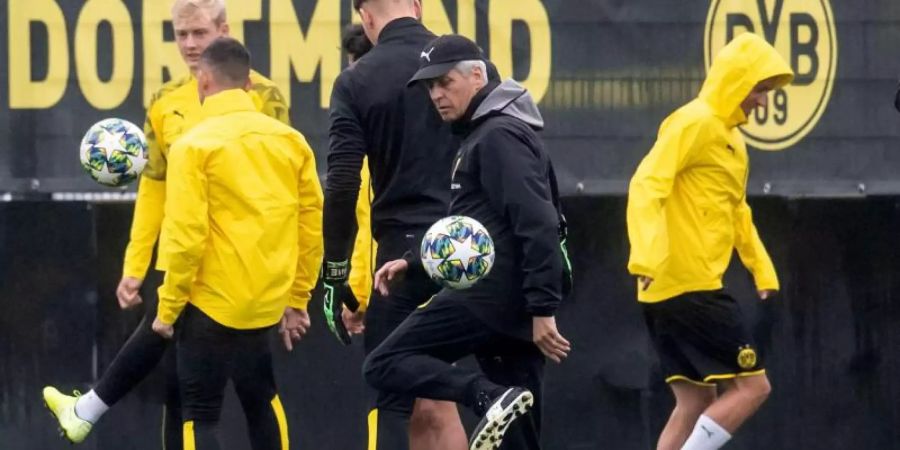 Trainer Lucien Favre (vorn) nimmt am Abschlusstraining teil. Der BVB rechnet sich durchaus Chancen gegen den FC Barcelona aus. Foto: Bernd Thissen