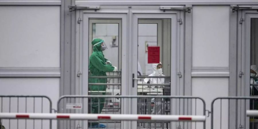 Vor dem Eingang zum Werksgelände der Firma Tönnies werden am Tag der Wiederaufnahme des Schlachtbetriebes im Juli 2020 in einem Testzentrum den Mitarbeitern Abstriche entnommen, um Tests auf Covid-19 durchzuführen. Foto: Guido Kirchner/dpa