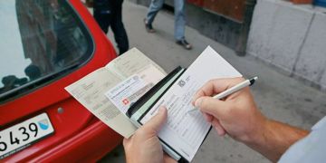 Ein Zürcher Polizist stellt eine Busse aus.