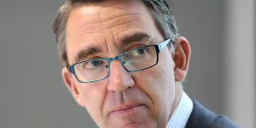Der Vorstandsvorsitzende der Kuka AG, Till Reuter (r), sitzt in der Kuka-Zentrale.