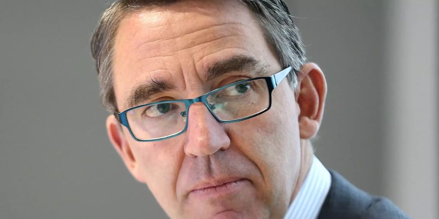 Der Vorstandsvorsitzende der Kuka AG, Till Reuter (r), sitzt in der Kuka-Zentrale.