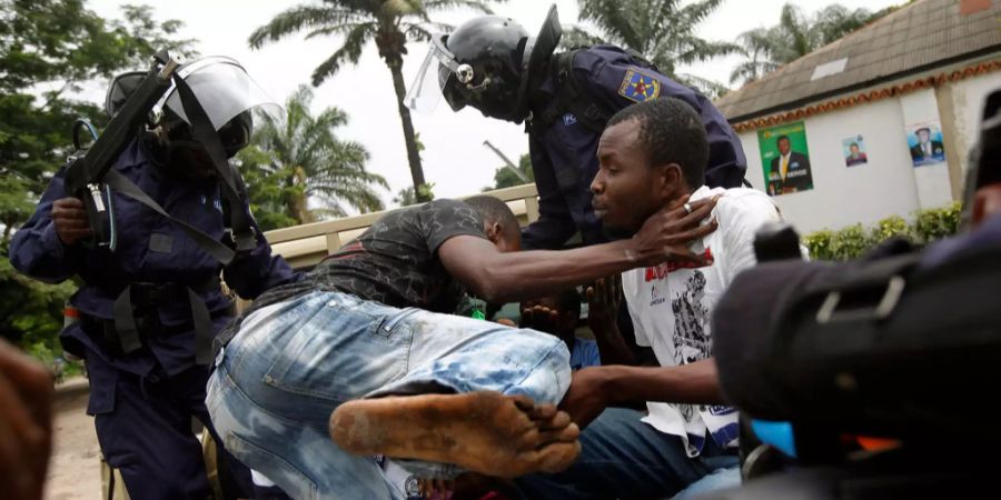 Polizisten greifen bei Ausschreitungen im Kongo ein.