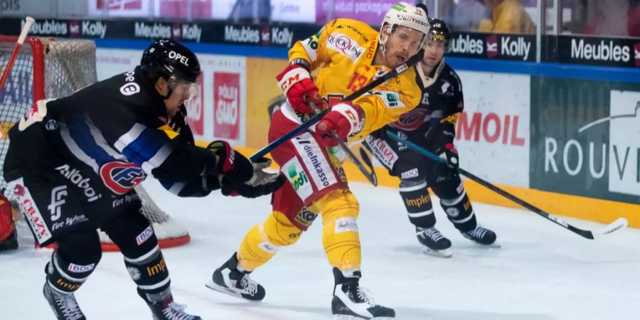 Fribourgs Lukas Lhotak, links, trifft Biesl Anssi Salmela mit dem Stock am Kopf, im Eishockey Meisterschaftsspiel der National League zwischen dem HC Fribourg Gottéron und dem EHC Biel in der BCF Arena in Fribourg.