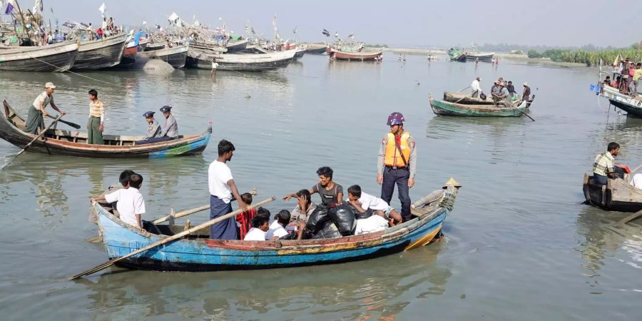 Myanmarische Polizisten eskortieren Rohingyas nach Sittwe.