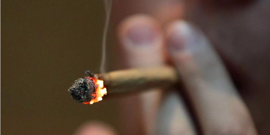 Ein Mann raucht in einem Coffee Shop in Maastricht (NLD) einen Joint mit Marihuana.