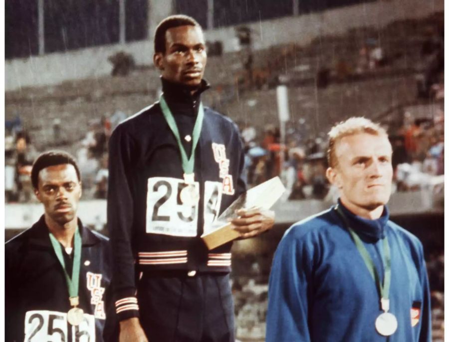 Goldmedaillengewinner Bob Beamon (M) steht bei der Siegerehrung zwischen Ralph Boston (USA, Bronze, l) und dem DDR-Weitspringer Klaus Beer, der die Silbermedaille gewann.