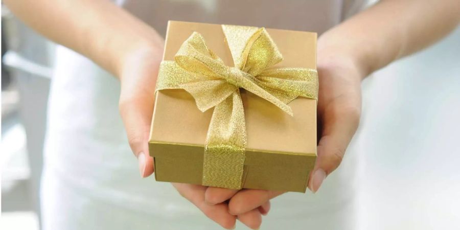 Eine Frau hält eine kleine Geschenkbox.