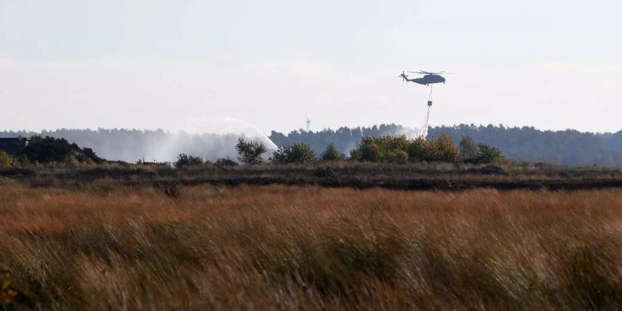 Ein Transporthubschrauber CH-53 der Bundeswehr gibt beim Moorbrand auf dem Gelände der Wehrtechnischen Dienststelle 91 (WTD 91) in Meppen (D) Wasser ab.