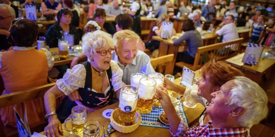 Gäste stossen nach der Eröffnung und Fassanstich beim Oktoberfest im Hofbräu Wirtshaus in Berlin mit ihren Mass an.