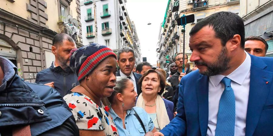 Matteo Salvini (r), Innenminister von Italien, schüttelt während eines Besuchs in Neapel einer Frau die Hand.