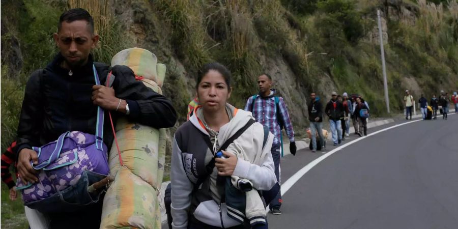 Venezolaner ohne Pässe laufen auf dem Pan American Highway in Kolumbien, um zur nächsten Migrationstelle in Rumichaca (ECU) zu gelangen.