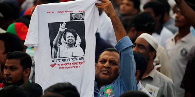 Ein Demonstrant hält ein Tshirt mit dem Abbild der ehemaligen Ministerpräsidentin Khaleda Zia hoch.