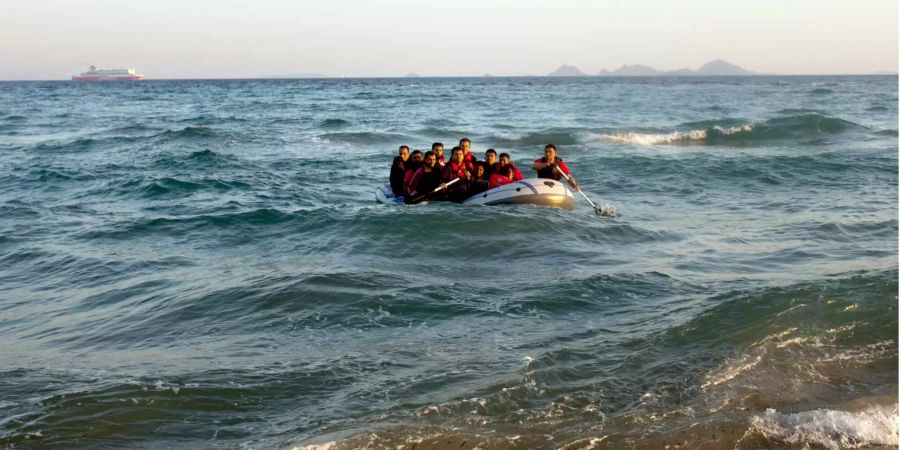 Migranten steuern in einem Schlauchboot auf die türkische Küste zu.